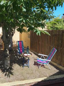 two chairs and a table sitting under a tree at Forza e avanti in Santa Teresita