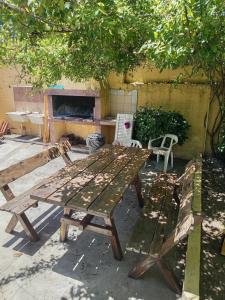 a picnic table and two benches in a yard at Forza e avanti in Santa Teresita