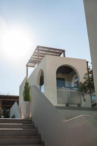 a house with stairs leading up to it at VAYA Suites by Omilos Hotels in Amoudara Herakliou