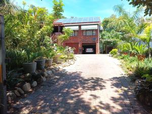 a driveway leading to a building with a solar roof at Cosy Cottage in Sedgefield