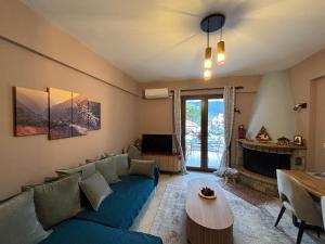 een woonkamer met een blauwe bank en een open haard bij Kalavryta Moments in Kalavrita
