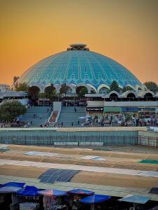 a large building with a large blue dome with people outside at Chorsu Old City in Tashkent