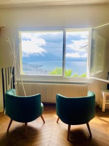 a room with two chairs and a large window at Lavaux Lodge - Romantic escape with magic views! in Chardonne