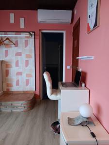 a room with a desk with a laptop on a pink wall at Alojamento local Patudos, Suite com terraço privado in Tavira +27 photos