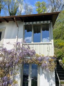 a house with a balcony with purple flowers on it at Lavaux Lodge - Romantic escape with magic views! in Chardonne