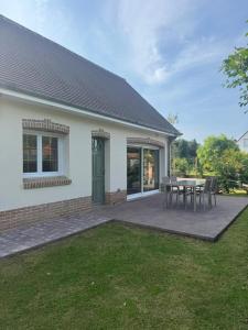 a house with a patio with a table and chairs at Merlimont Spa Gîte Au Gîte des Colibris Merlimont in Merlimont