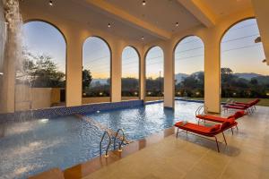 una piscina con sedie rosse e una fontana di Still River Suites by ELIVAAS a Thūr