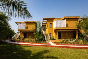 una casa gialla con scale in un cortile di Still River Suites by ELIVAAS a Thūr