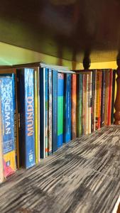 a row of books on a book shelf at Casa Refúgio Cataratas by Grasi in Foz do Iguaçu