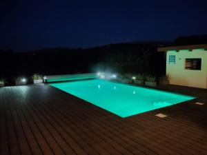 een zwembad dat 's nachts verlicht is bij Casa Eloy in Argüero