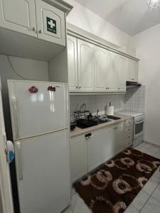 a kitchen with white cabinets and a white refrigerator at Δεσκάτη-Deskati apartment in Deskáti +4 photos