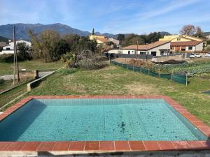an empty swimming pool in a yard with a house at Alojamiento Rural Montseny in Breda