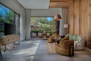 a living room with a couch and a tv at Samanea Wellness Resort in Phumĭ Tŭk Lŭy