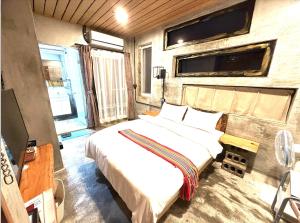 una camera con due letti e una tv di 巴斯拉岸民宿 a Chenggong