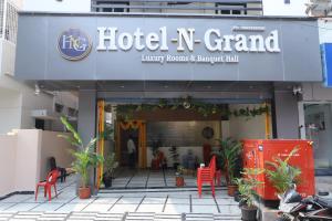 a hotel n grand with red chairs in front of it at Hotel N Grand in Miriālgūda