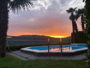 a swimming pool with a sunset in the background at Casa Bellavista Rovio in Rovio