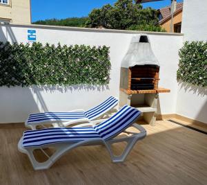 2 stoelen op een patio met een open haard bij Apartamentos Ézaro Beach in Dumbría