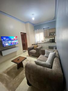a living room with two couches and a flat screen tv at Merry in Kampala