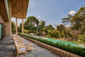 a row of chairs and a pool at a resort at Samanea Wellness Resort in Phumĭ Tŭk Lŭy