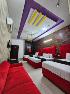 una camera d'albergo con due letti e un divano di Hotel The Tulip a Lahore