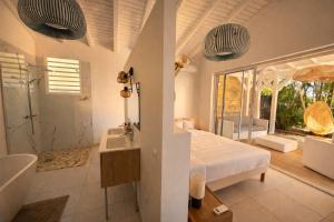 a bedroom with a bed and a tub and a sink at Villa Cokoon in Saint-François +32 photos