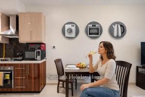 a woman sitting at a table drinking a glass of water at Studio for 4 just 5 Min Walk to Burj Khalifa, Downtown Dubai, Tower Elite 1 in Dubai +11 photos