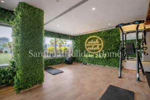 a room with a green wall with a gym at Studio for 4 just 5 Min Walk to Burj Khalifa, Downtown Dubai, Tower Elite 1 in Dubai