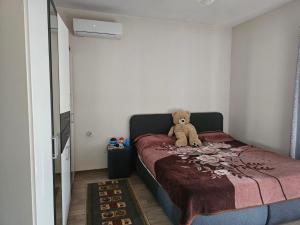 a teddy bear sitting on a bed in a bedroom at Kristina Guesthouse in Librazhd