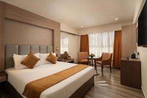a hotel room with a large bed and a desk at Classik Fort Inn & Suites in Cochin
