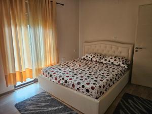 a bedroom with a bed and a window at Kristina Guesthouse in Librazhd