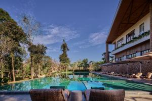 a swimming pool in front of a building at Samanea Wellness Resort in Phumĭ Tŭk Lŭy