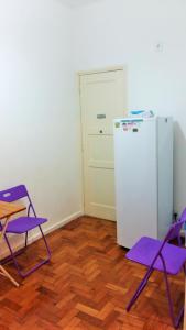 uma cozinha com cadeiras roxas e um frigorífico em Apartamento Lausanne no Rio de Janeiro