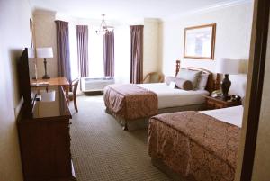 A bed or beds in a room at Cow Hollow Inn and Suites