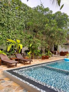 einem Pool vor einem Gebäude mit Bäumen in der Unterkunft Green Grove in Matara