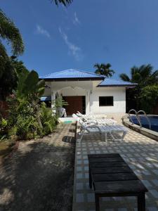 a group of white chairs sitting in front of a house at SU house Koh Phangan in Thong Nai Pan Yai