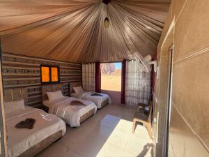 a bedroom with three beds in a tent at Starry Nights Luxury Camp in Wadi Rum