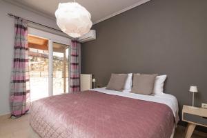 a bedroom with a bed and a large window at Villa Gisele with Private Pool in Tragaki +9 photos