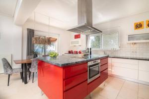 a kitchen with red cabinets and a counter top at Villa Gisele with Private Pool in Tragaki