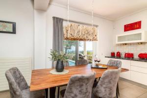 a dining room with a wooden table and chairs at Villa Gisele with Private Pool in Tragaki