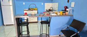 una cucina con bancone e sgabelli di Casa do ViajanteBr a Barreirinhas