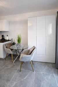 ein Esszimmer mit Glastisch und Stühlen in der Unterkunft Exklusive Moderne Wohnung Hanau in Hanau am Main