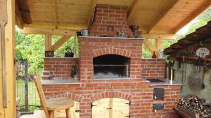 een bakstenen buitenoven met een tafel en een stoel bij Casa mea de vacanta in Baia-Sprie