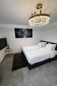 ein Schlafzimmer mit einem großen Bett und einem Kronleuchter in der Unterkunft Exklusive Moderne Wohnung Hanau in Hanau am Main