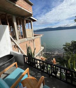 a balcony of a house with a view of the water at Janji Maria Cottage in Tuk Tuk