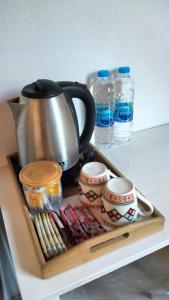 a tray with a tea kettle and cups and water bottles at Little Shark bungalow in Ban Bang Bao +17 photos