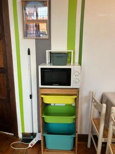 un forno a microonde in cima a una mensola in una stanza di Maison Corneille proche de Lille a Hem Altre 11 foto