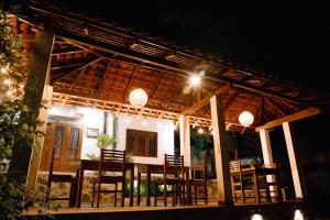 a house with a table and chairs at night at Brown Birds Villa in Tangalle