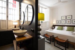 a bathroom with a sink and a bed and a mirror at MDD4 Health Experience Hotel - Adults Only in Seville +91 photos