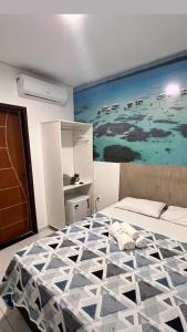 een slaapkamer met een bed met een groot schilderij aan de muur bij pousada agua viva in Maragogi