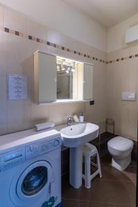 een badkamer met een wasmachine en een wastafel bij Suite Carpiano in Melegnano